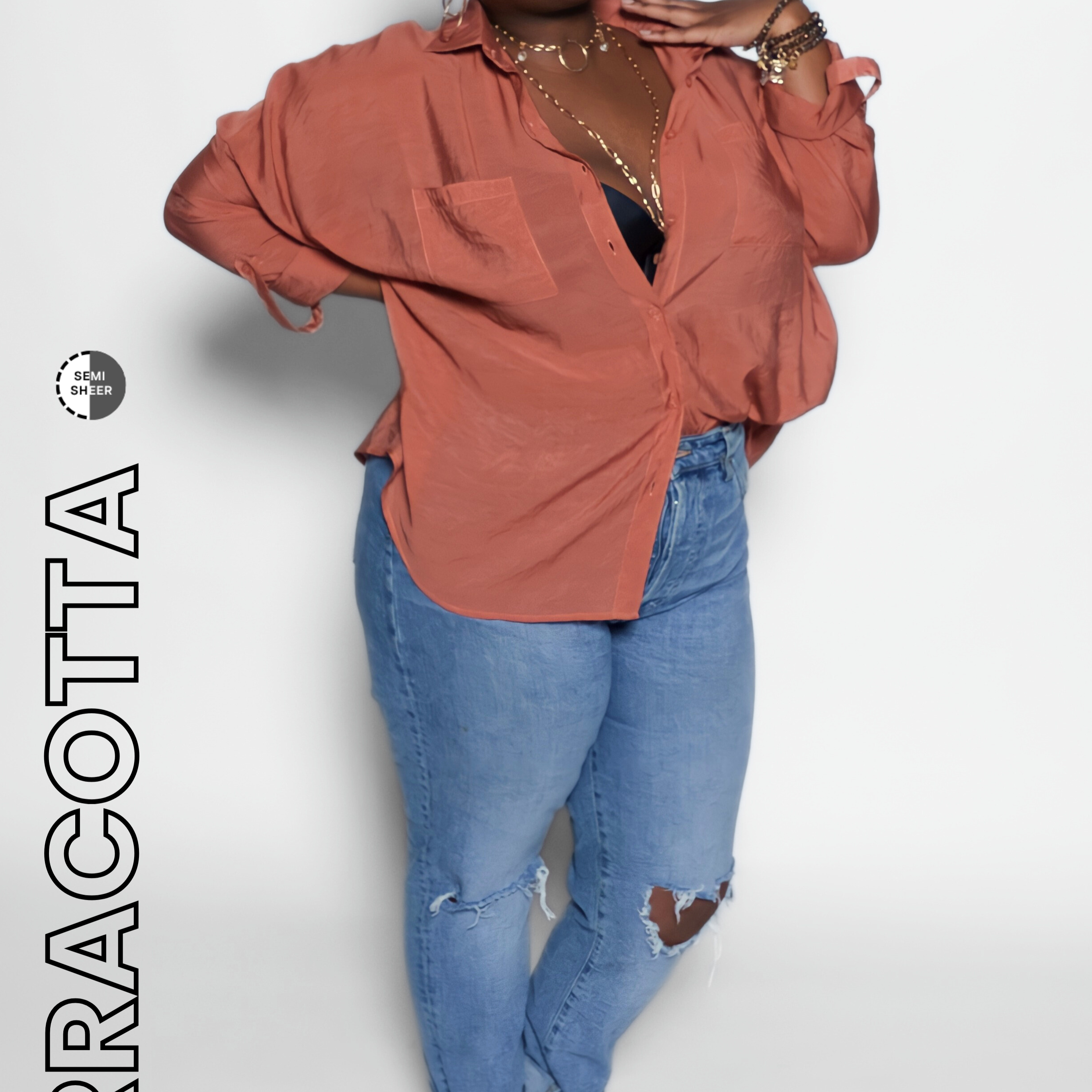 Woman wearing a terracotta blouse and blue jeans on a white background