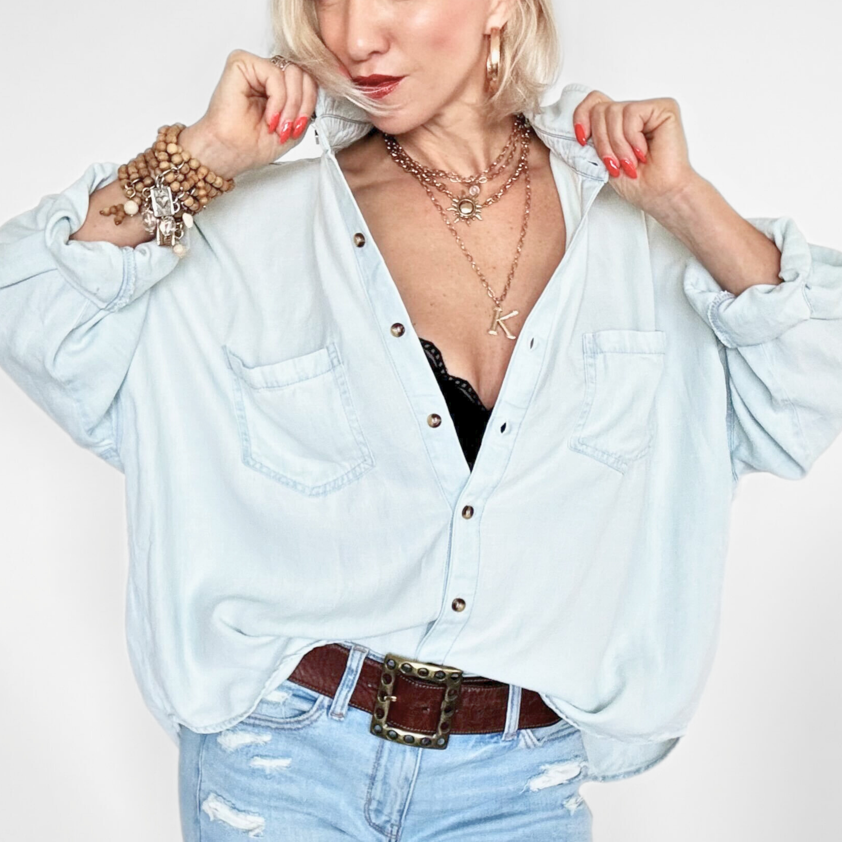 Woman wearing a light blue shirt and jeans with a white background