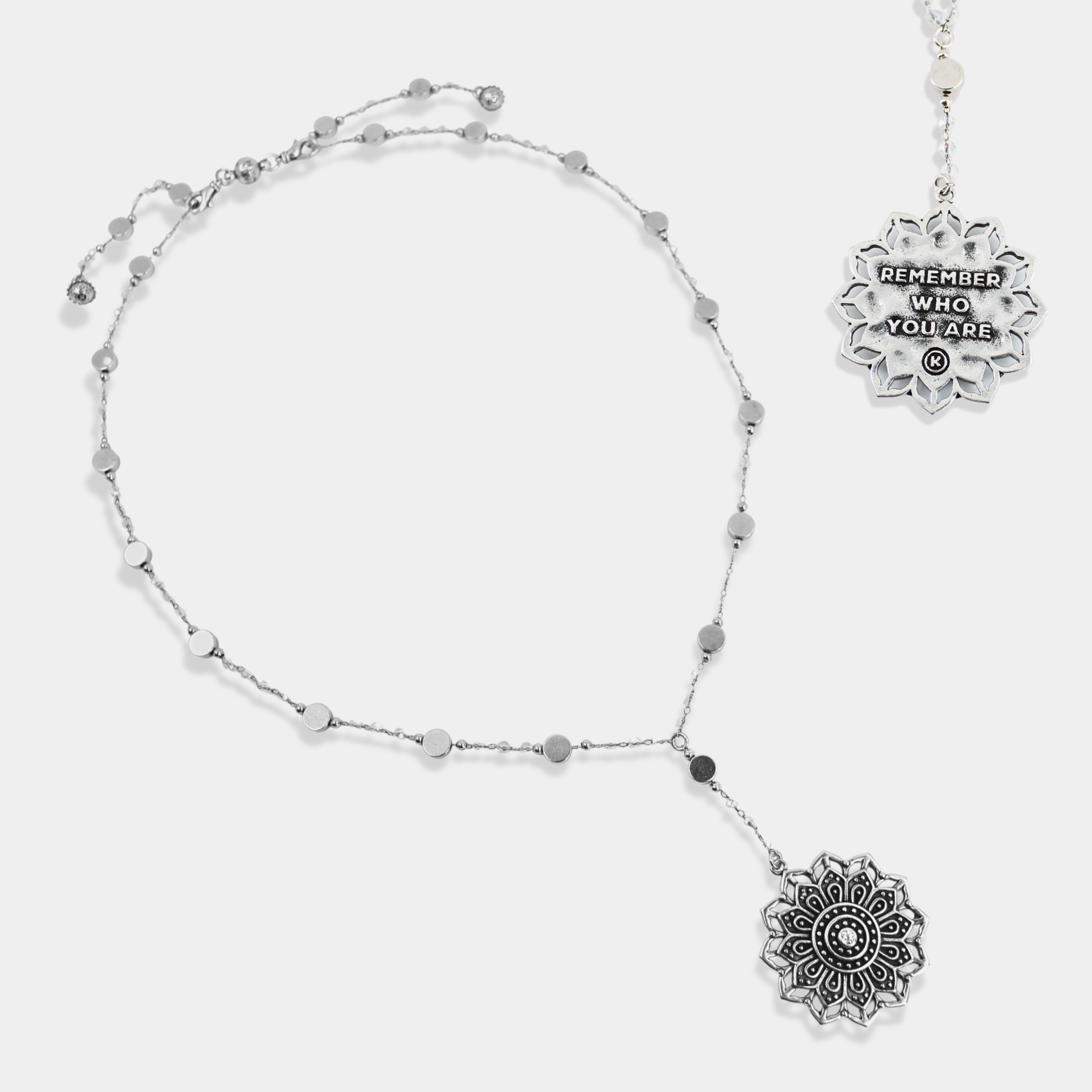 Silver necklace with decorative pendants on a white background
