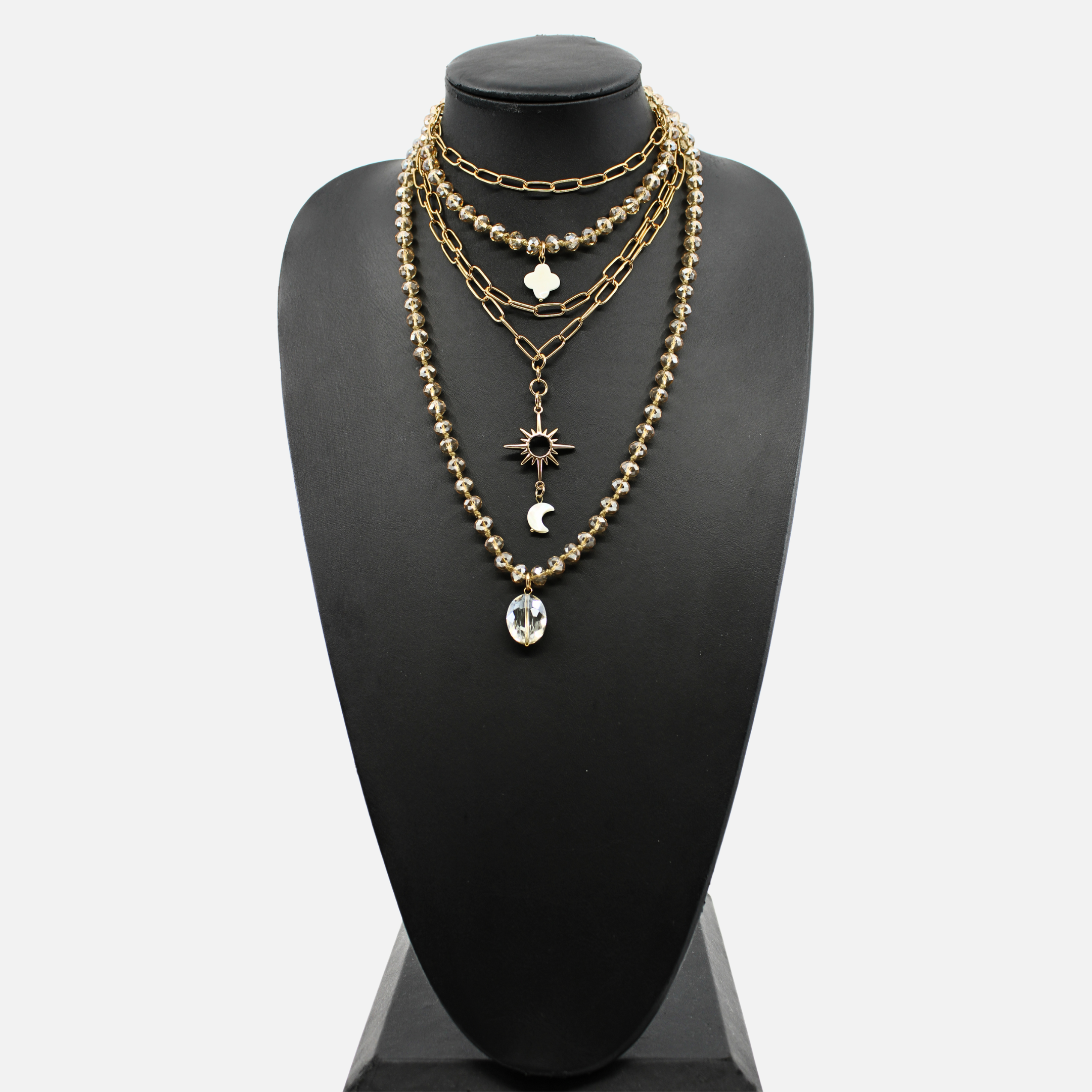Gold chain necklace with various pendants on a black mannequin bust.
