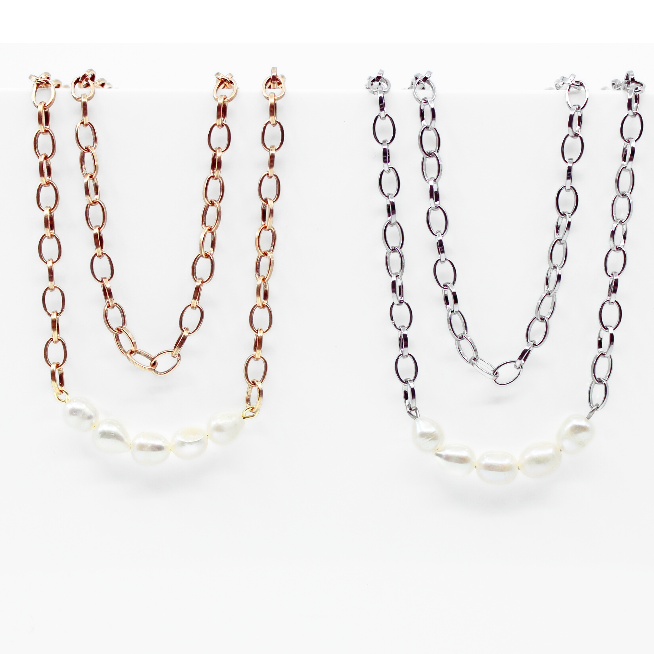 Two layering chain necklaces with pearl accent stones, one plated in gold and the other in silver, displayed against a white background.