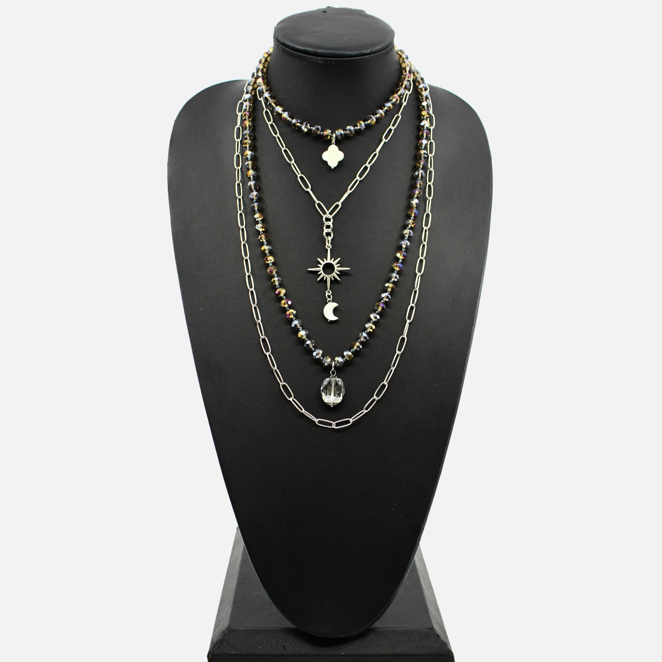 Necklace with multiple chains and pendants on a black mannequin bust.