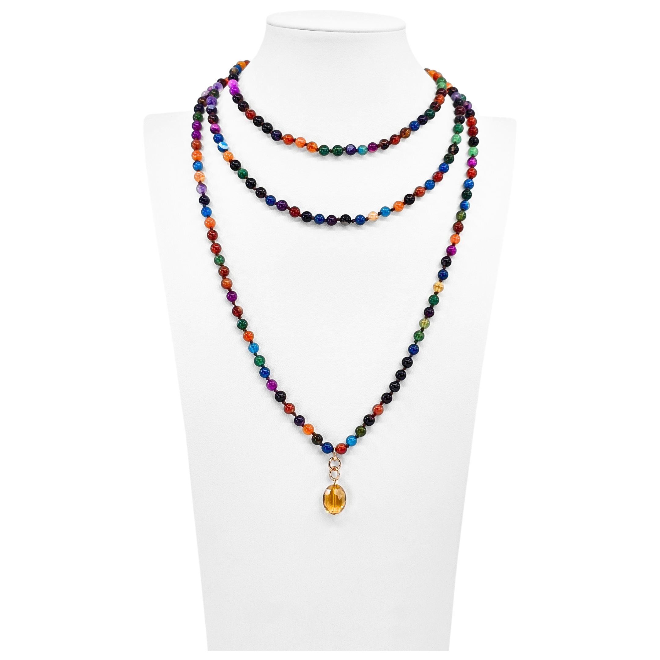 Colorful beaded necklace with a yellow pendant on a white mannequin.