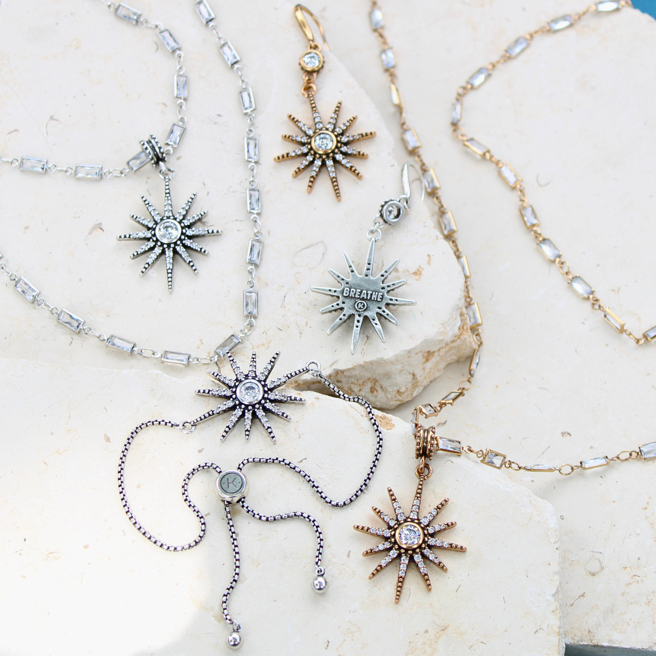 Sun-shaped jewelry pieces on a stone surface