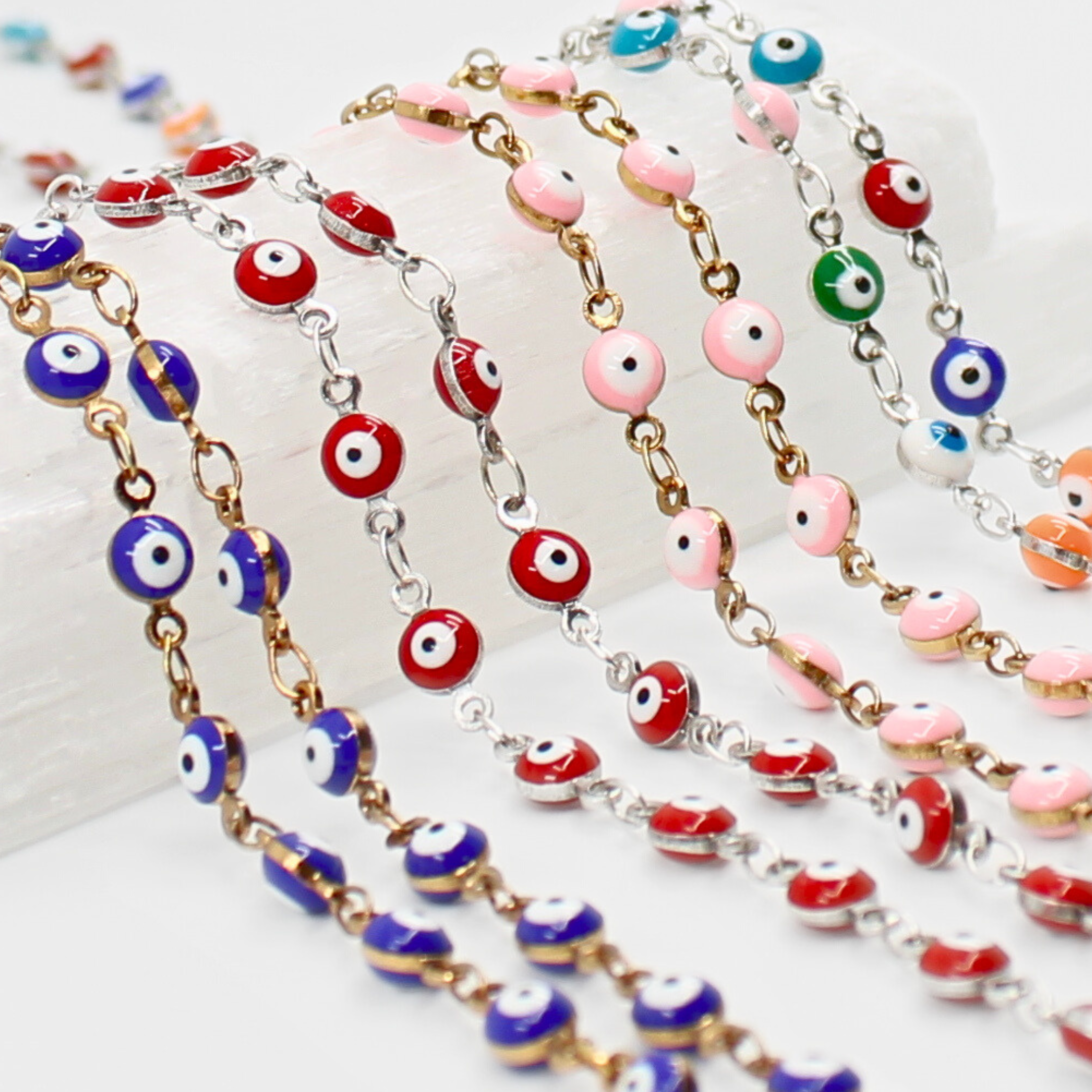 Colorful evil eye beaded necklaces on a white surface