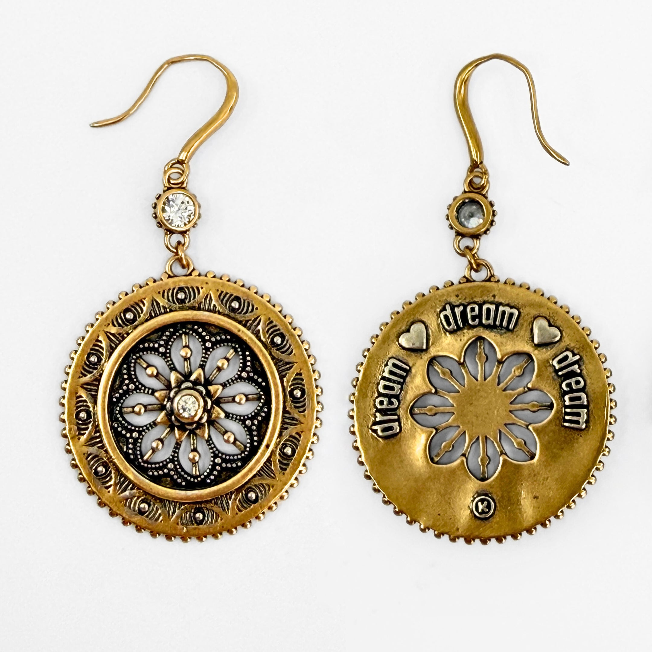 Pair of gold and bronze earrings with floral designs on a white background