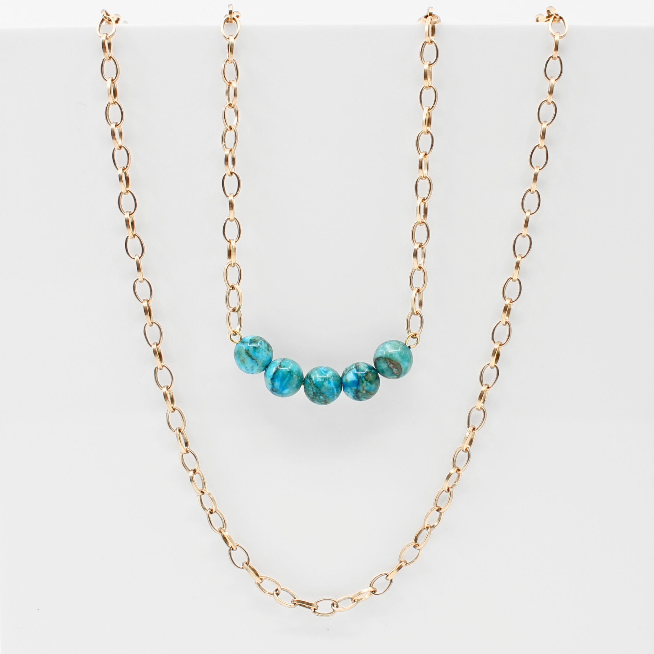 Stainless steel necklace featuring a gold chain with a row of five Aqua Terra Jasper beads, beautifully marbled in blue. Perfect for layering.