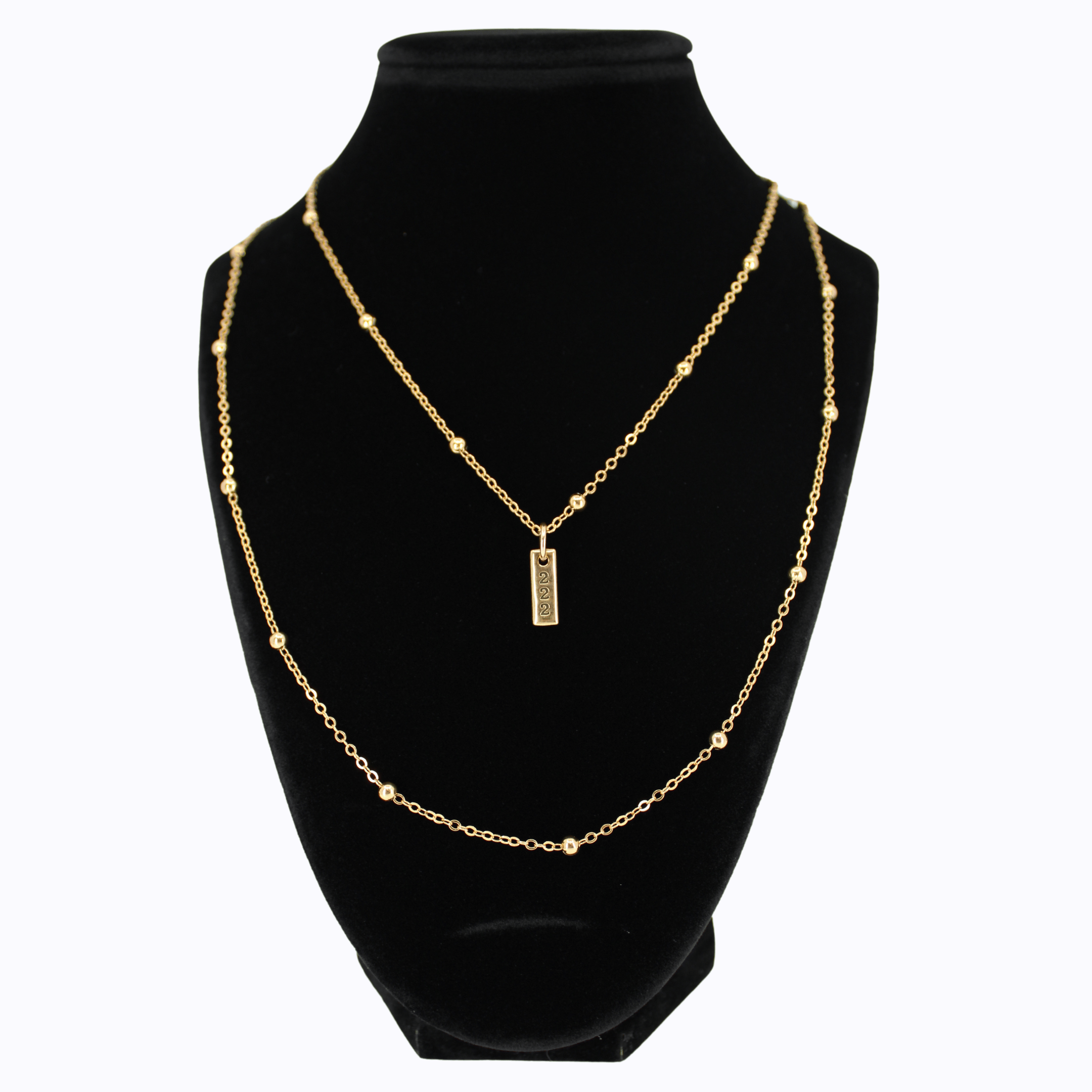 Gold necklace with a pendant on a black mannequin bust