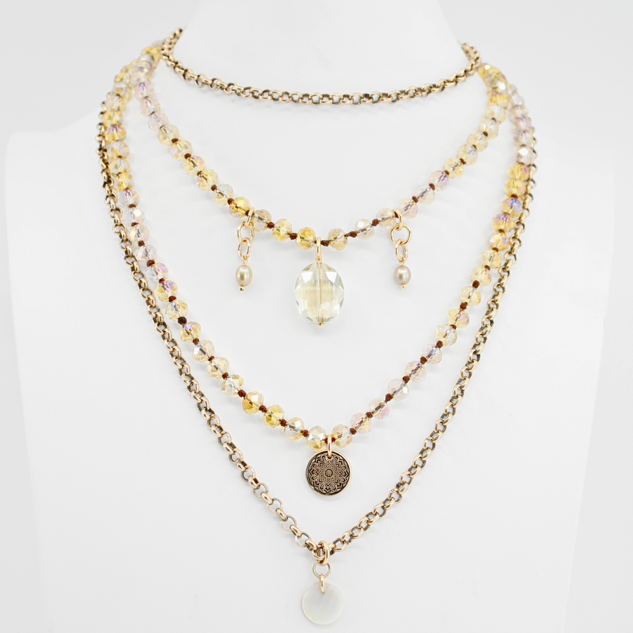 Stack of layered necklaces with beads and pendants on a white background