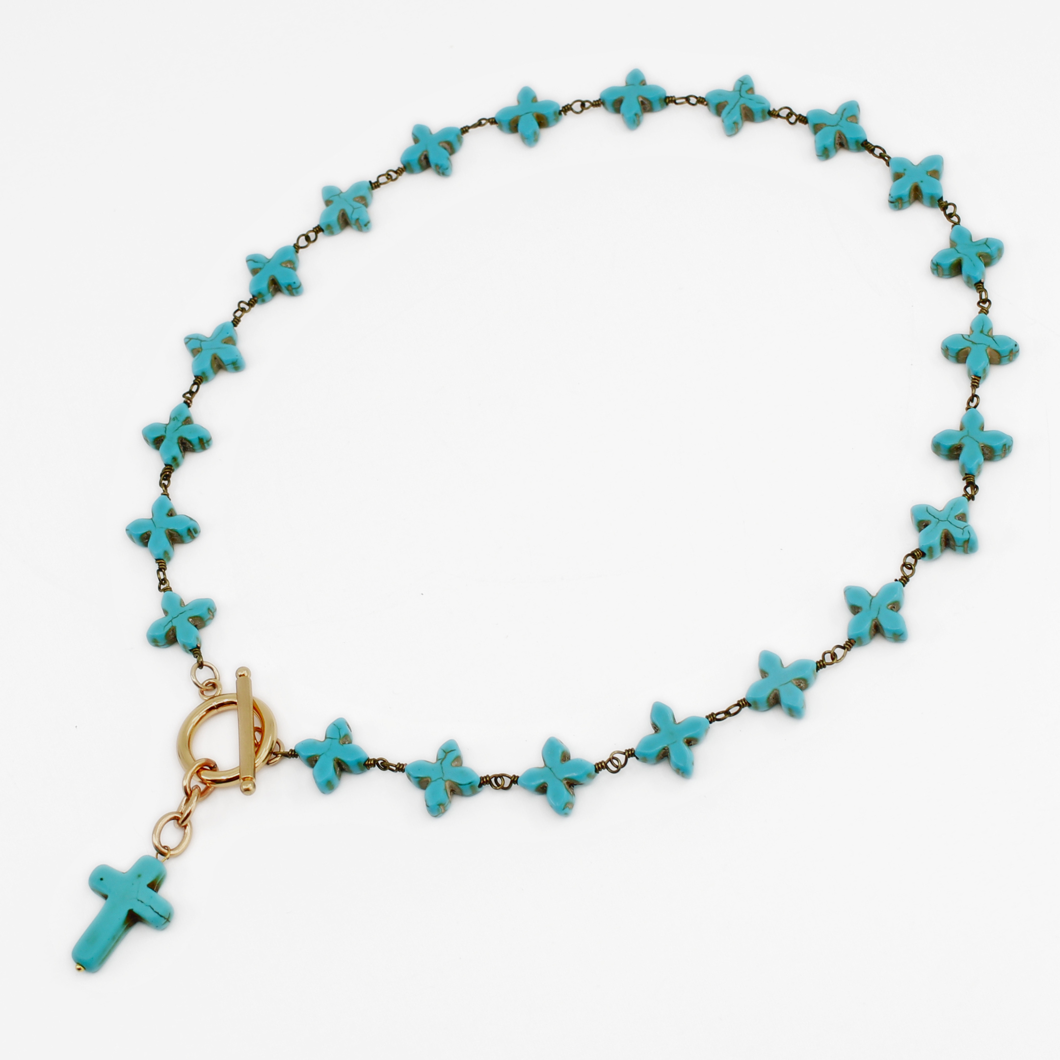 Turquoise cross necklace on a white background