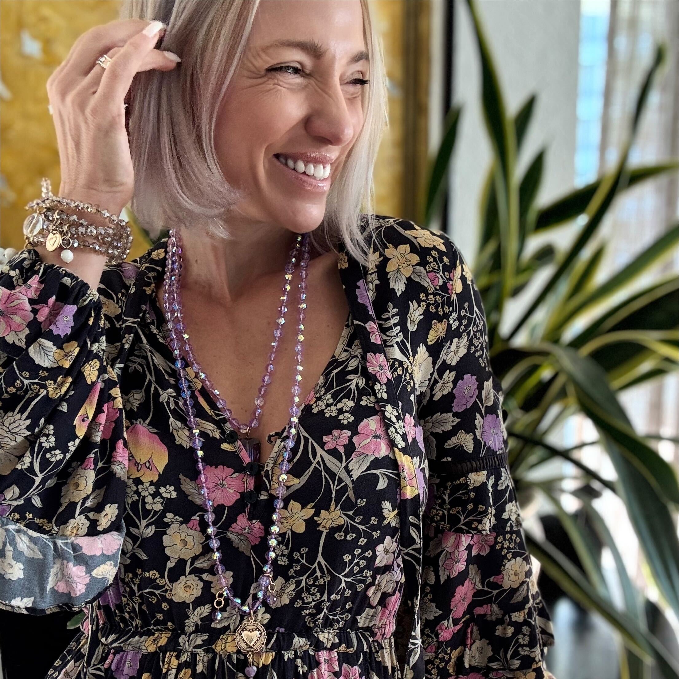 Woman wearing a floral dress with a plant in the background