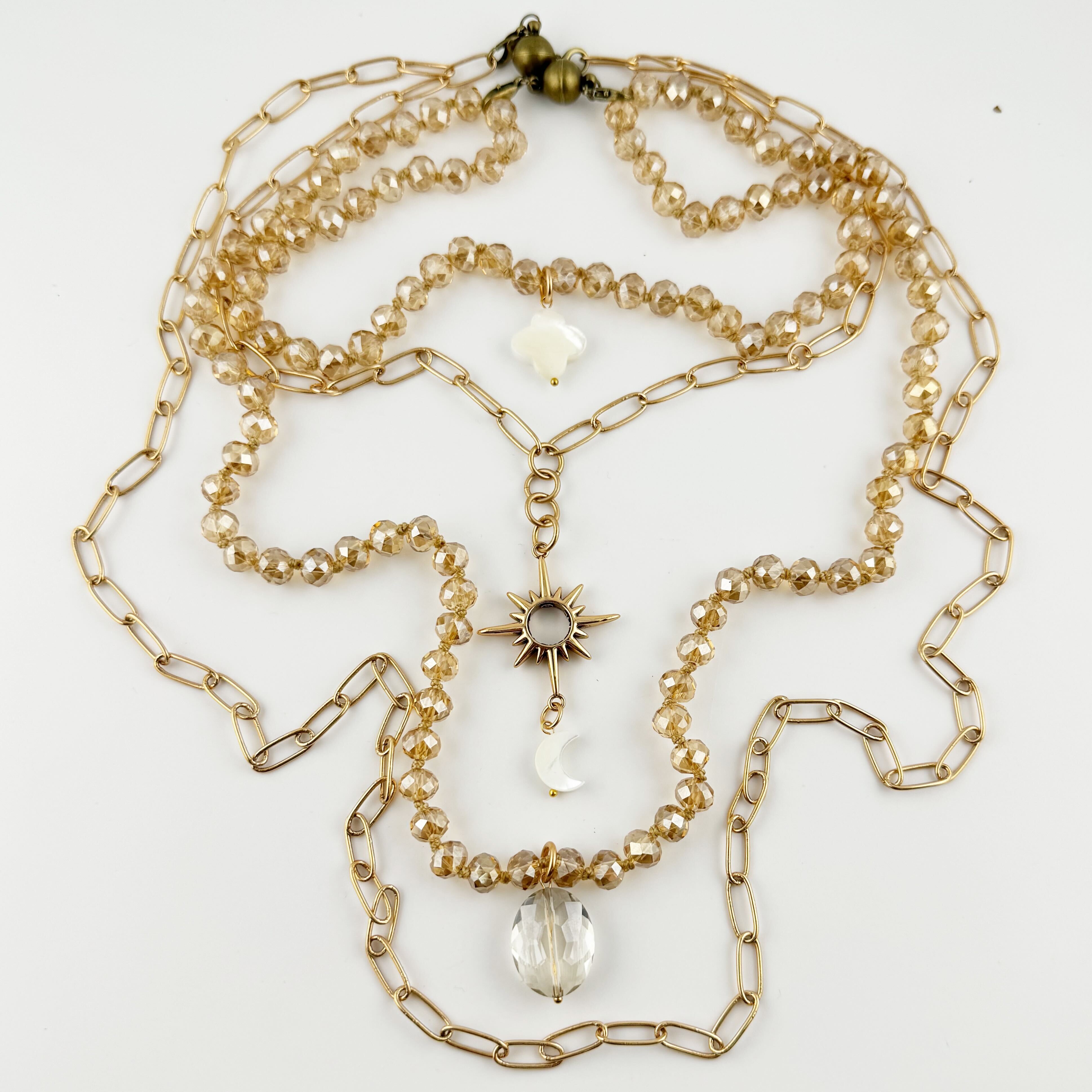 Gold chain necklace with beads and a star pendant on a white background