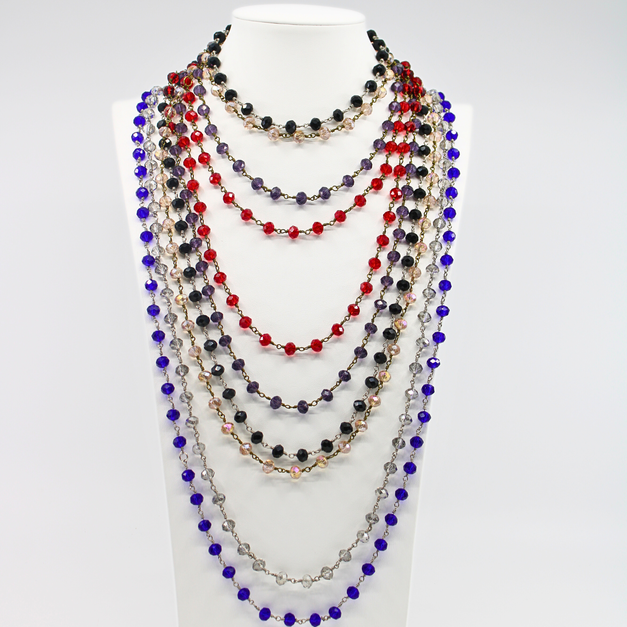 Multicolored beaded necklaces on a white mannequin bust against a white background