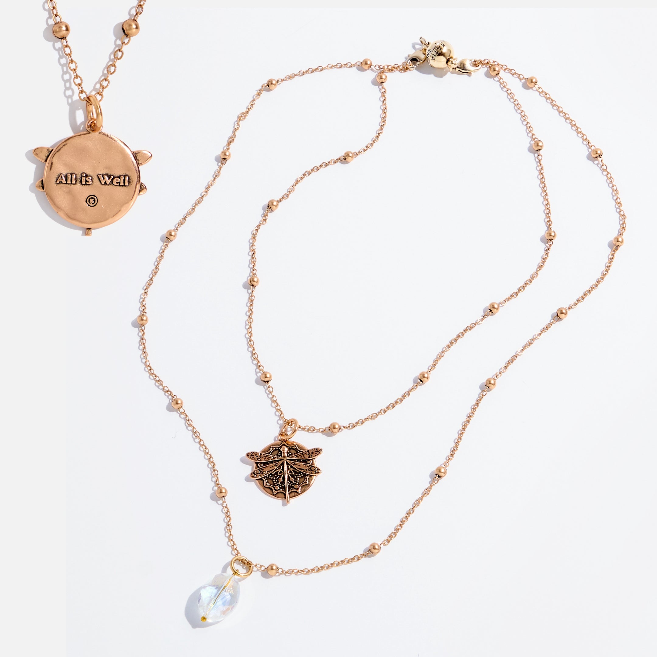 Gold necklace with pendant and pearl drop on white background