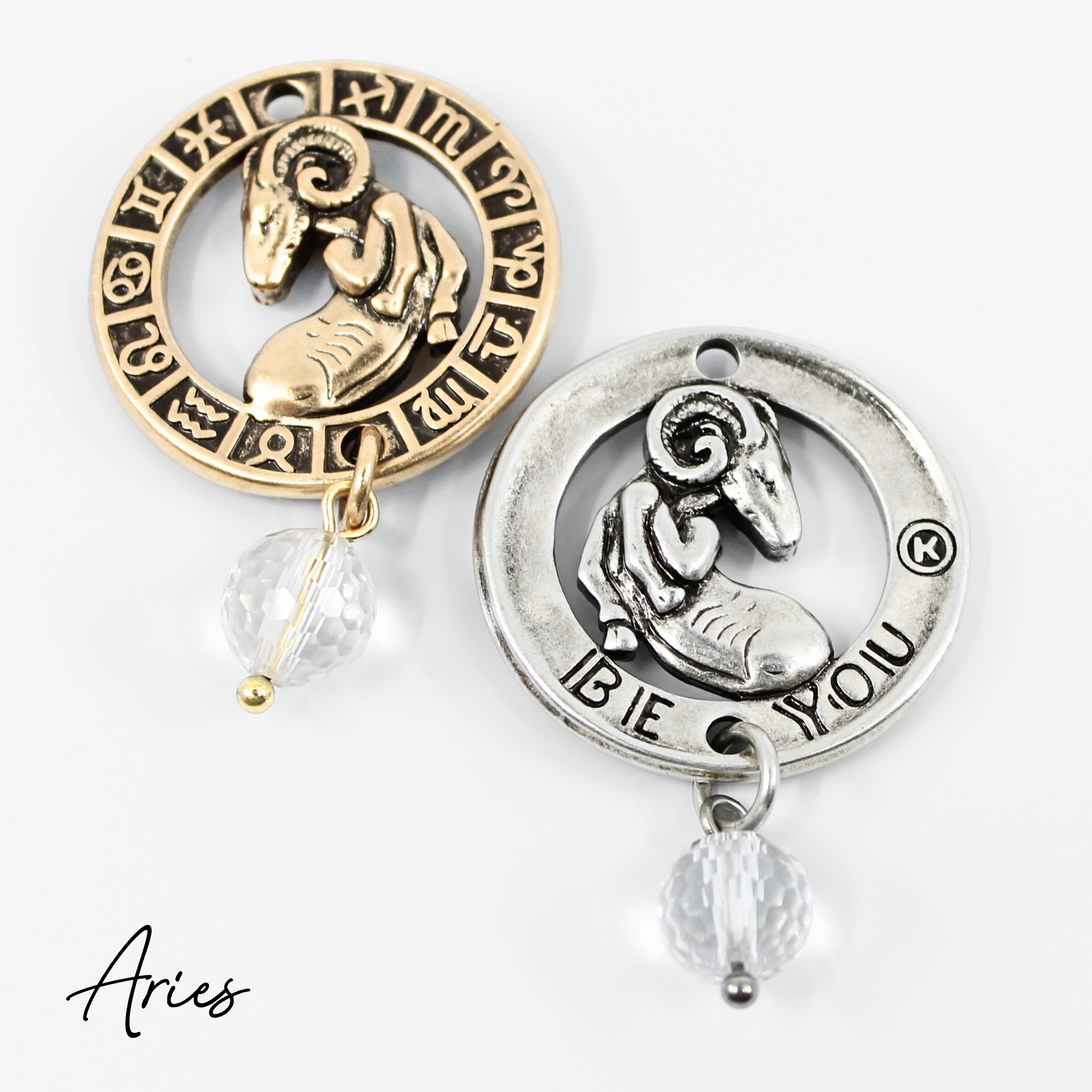 Two necklaces with gold and silver chains, featuring circular pendants with zodiac signs, and faceted crystal quartz accents.