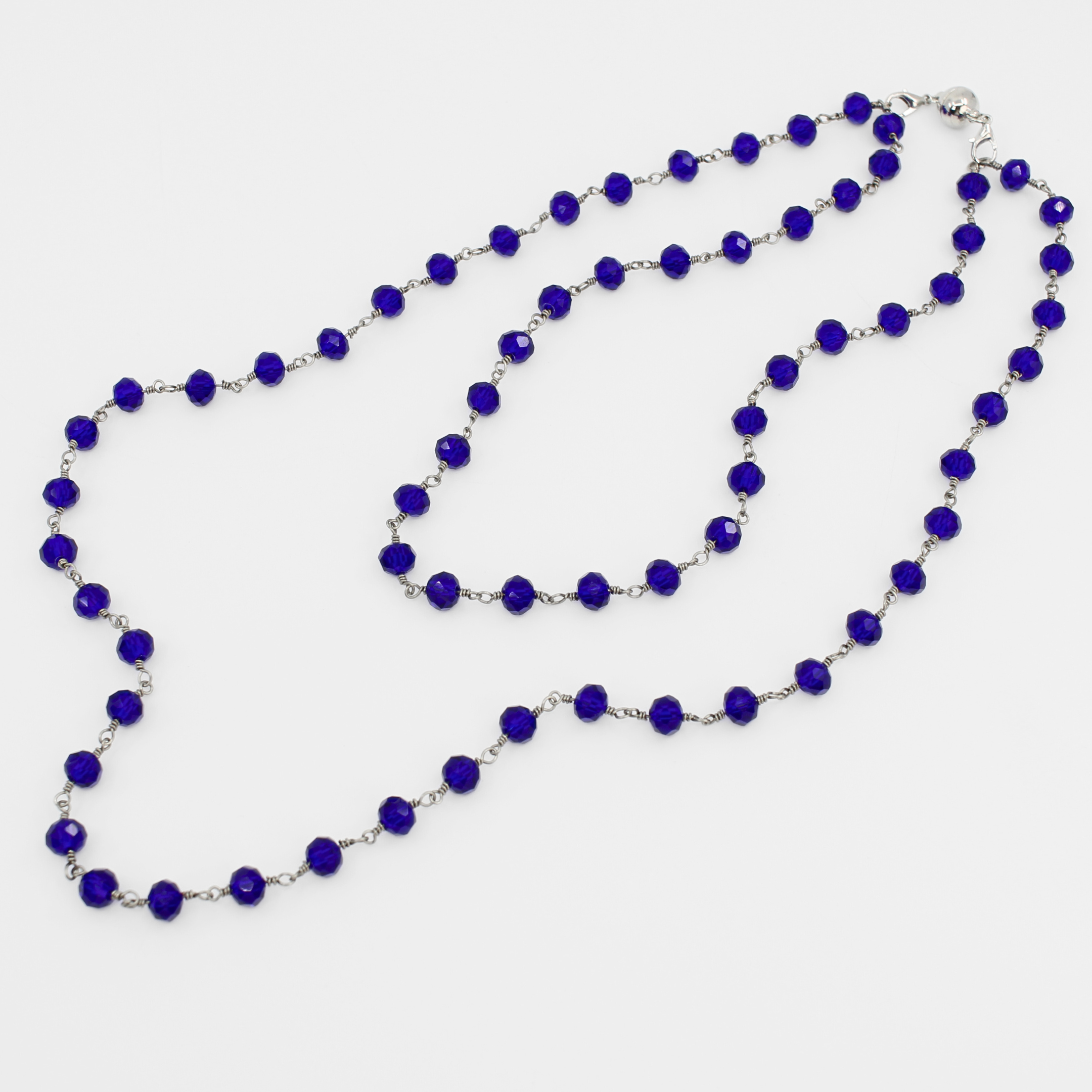 Long necklace with blue beads on a white background
