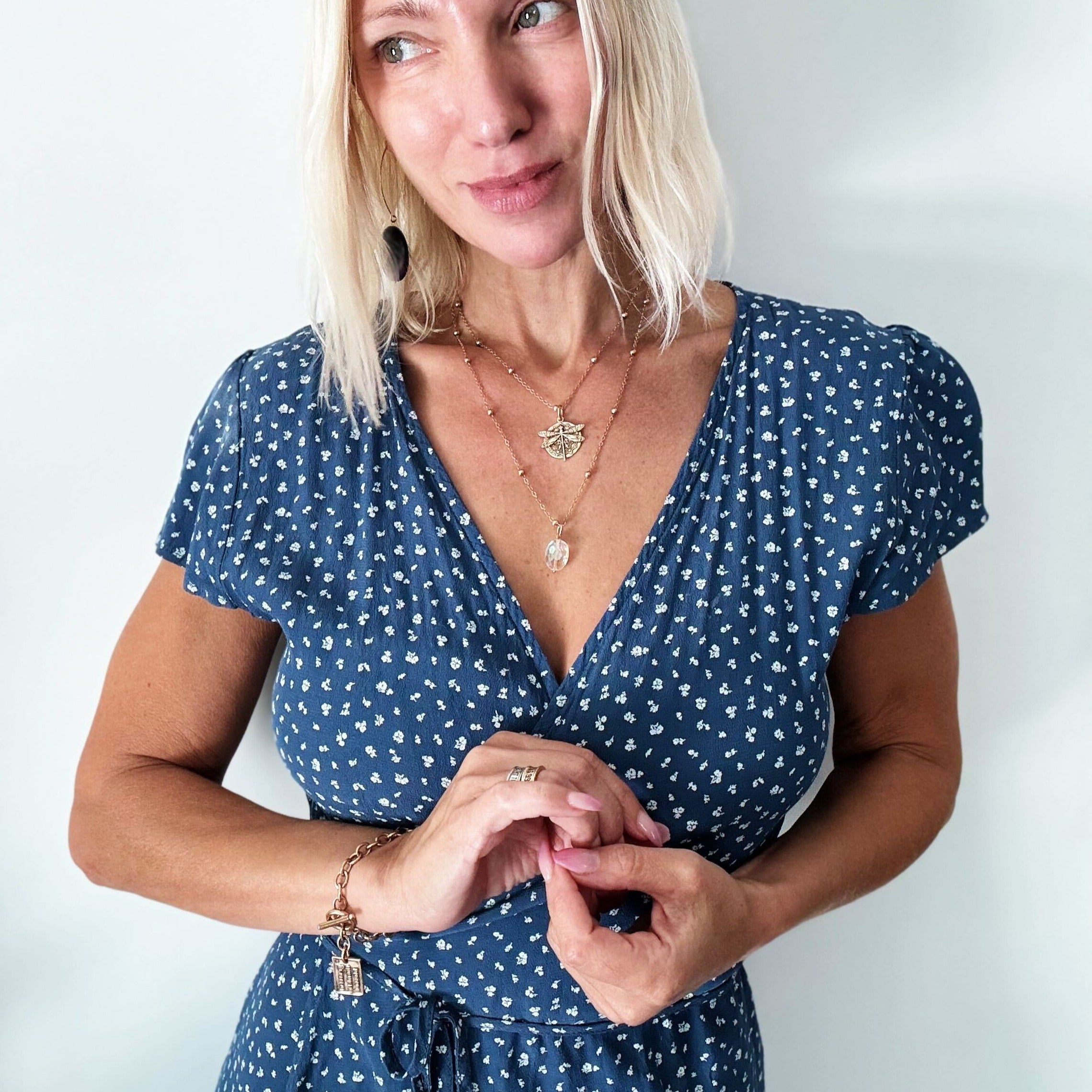 dragonfly pendant detail in gold and silver with message on back reads "all is well"