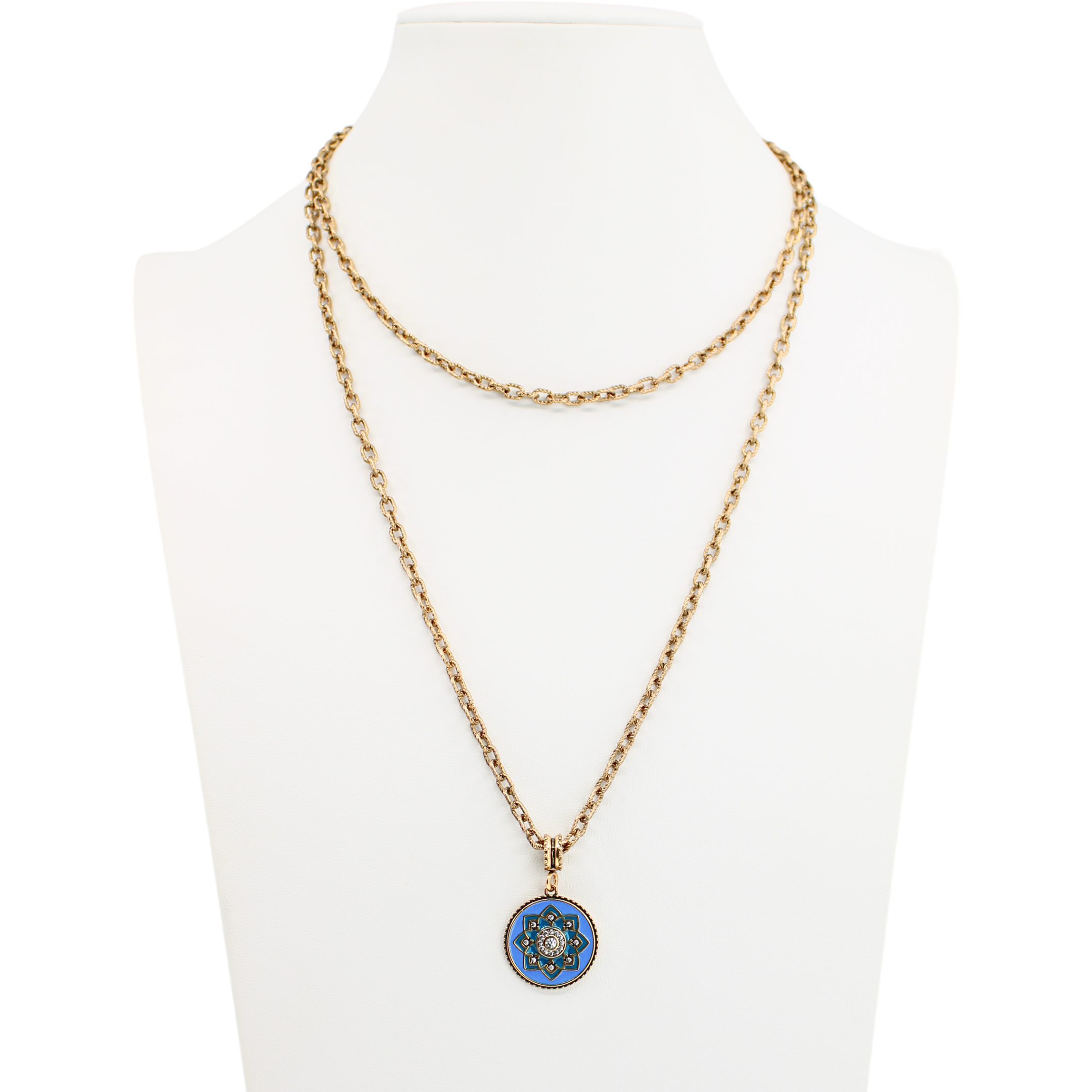 Gold necklace with a blue pendant on a mannequin bust against a white background