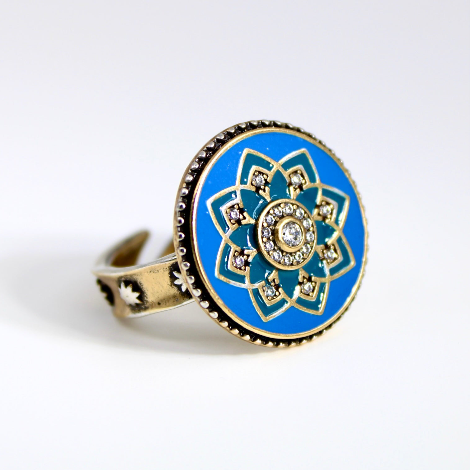 Ring with blue floral design and gold accents on a white background