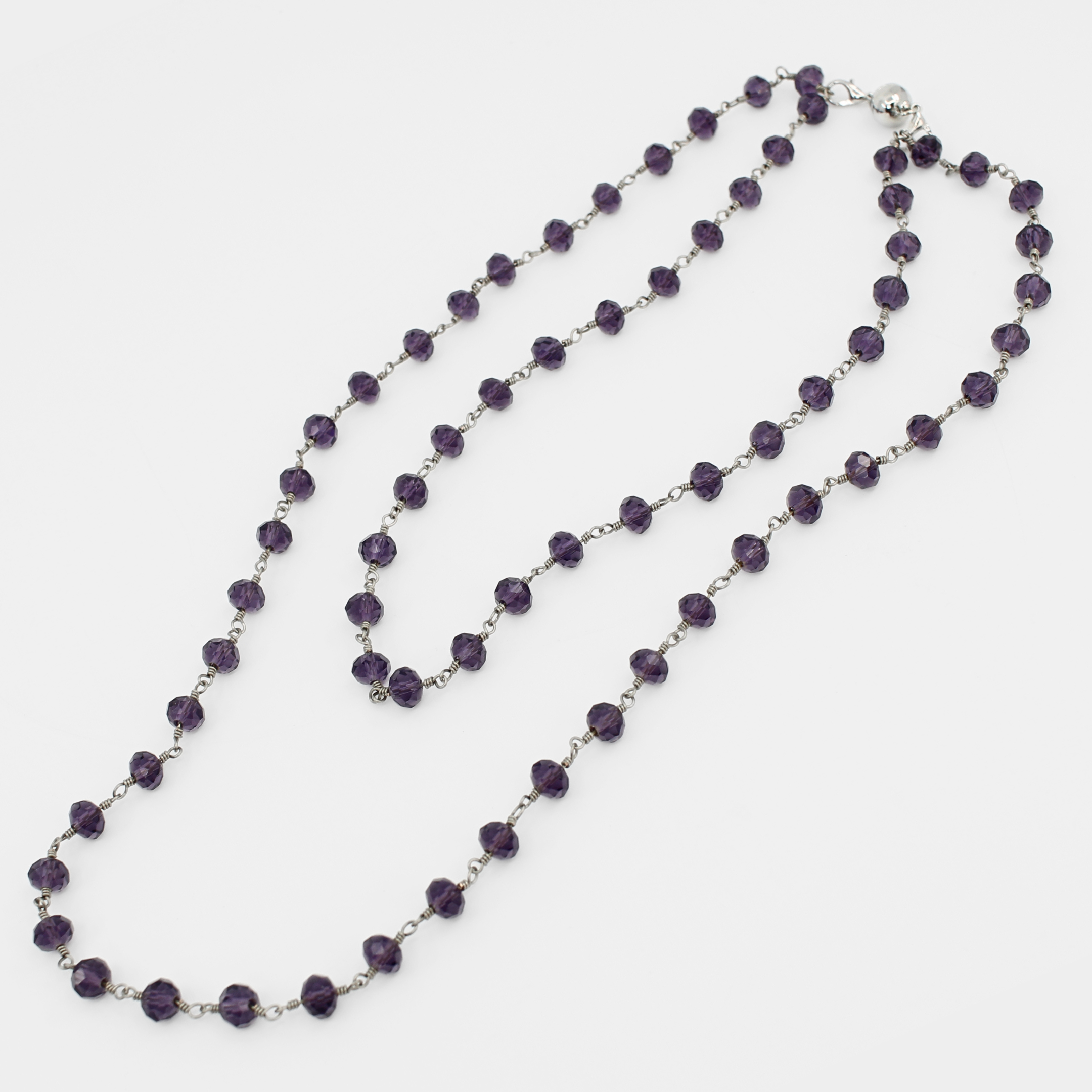 Purple beaded necklace on a white background