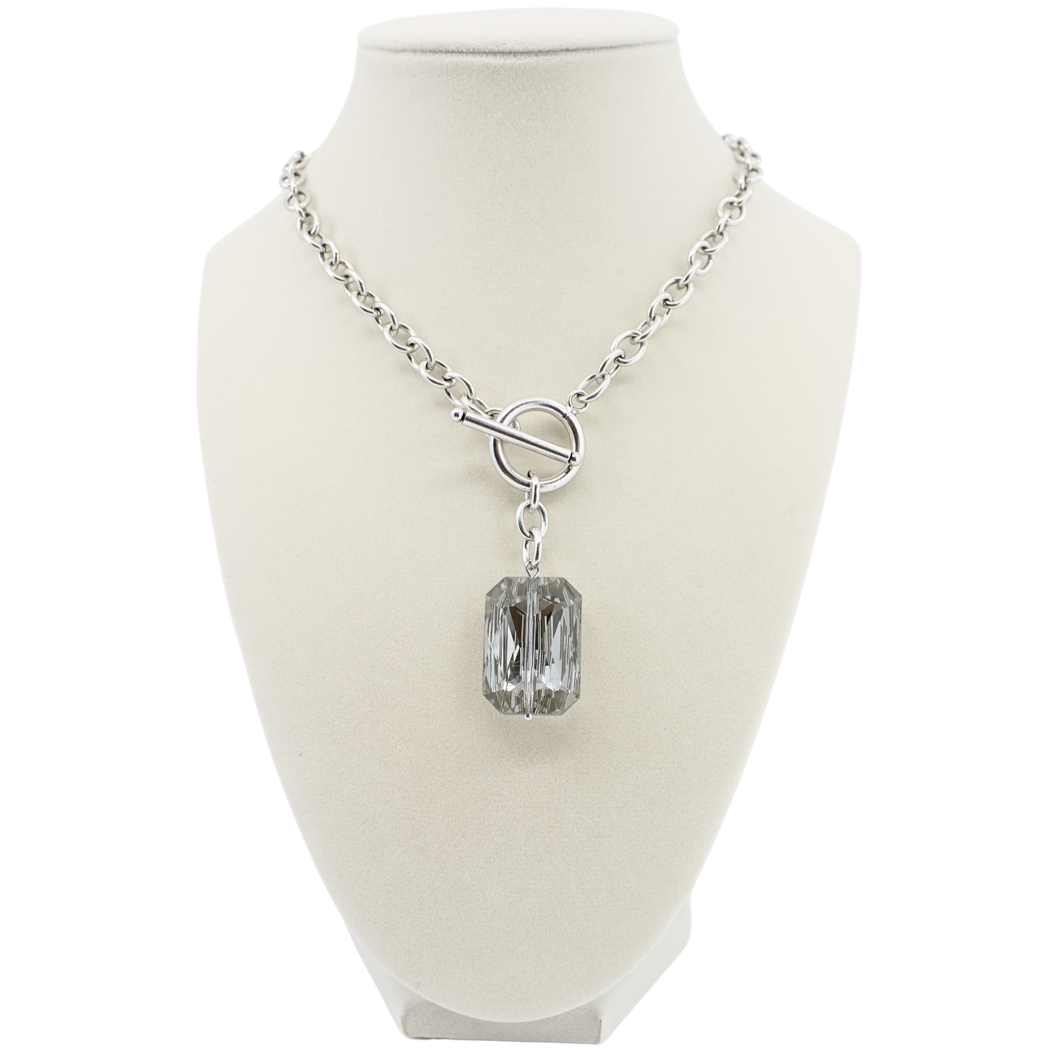 Silver necklace with a rectangular crystal pendant on a mannequin bust.