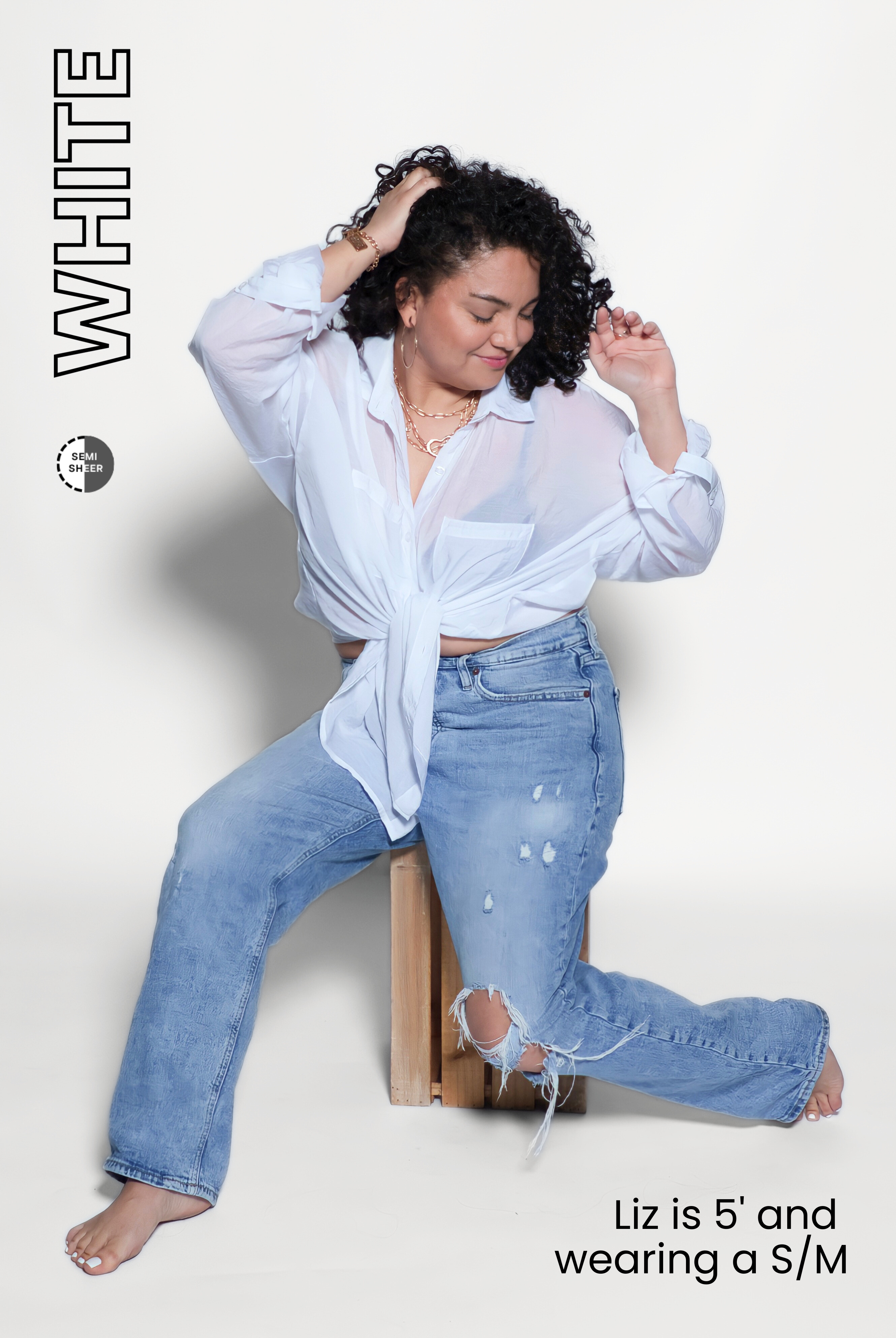 Woman wearing a white shirt and blue jeans sitting on a wooden block against a white background.