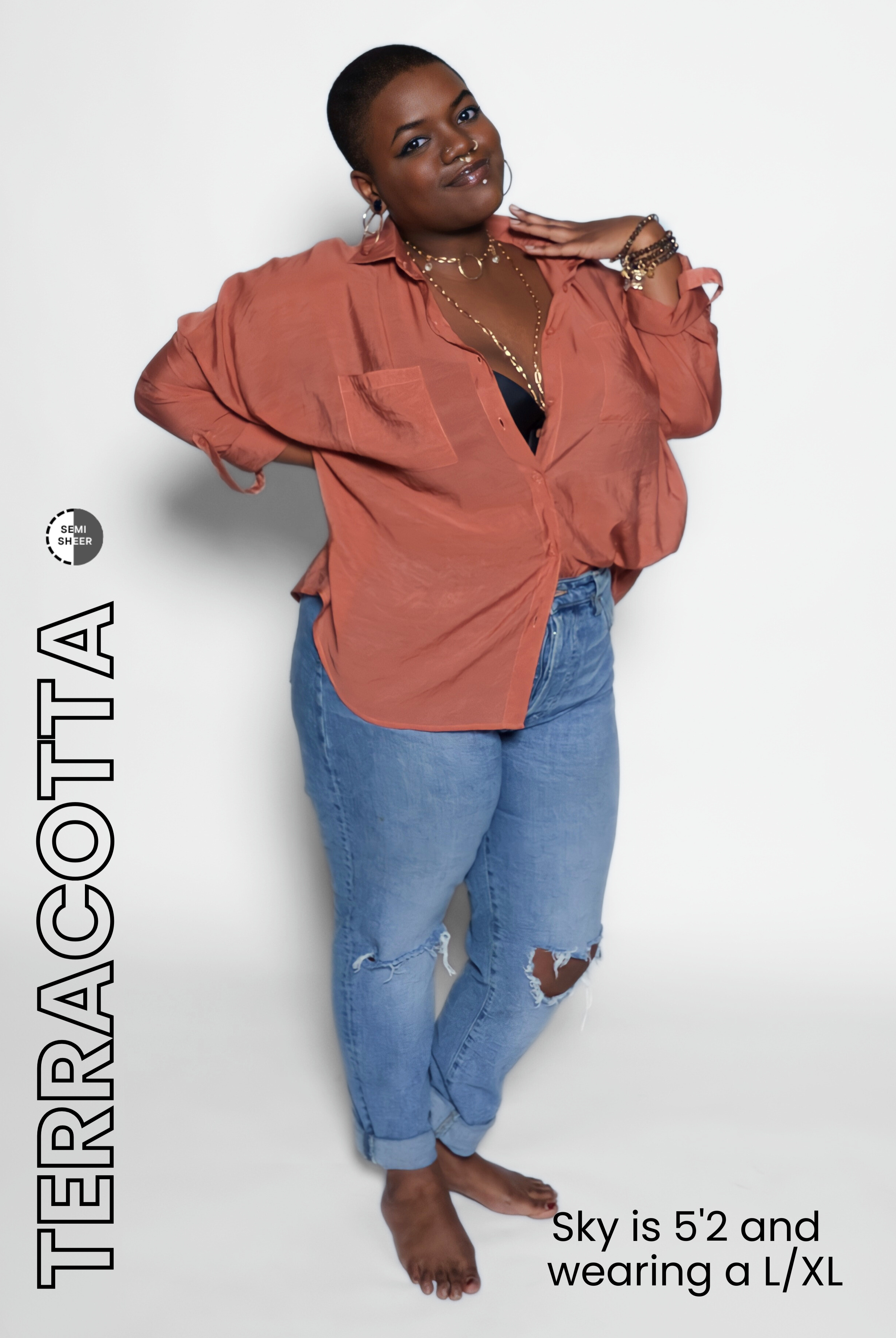 Woman wearing a terracotta blouse and blue jeans on a white background