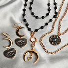 Gold and black jewelry set including necklaces, bracelets, and earrings on a light gray background