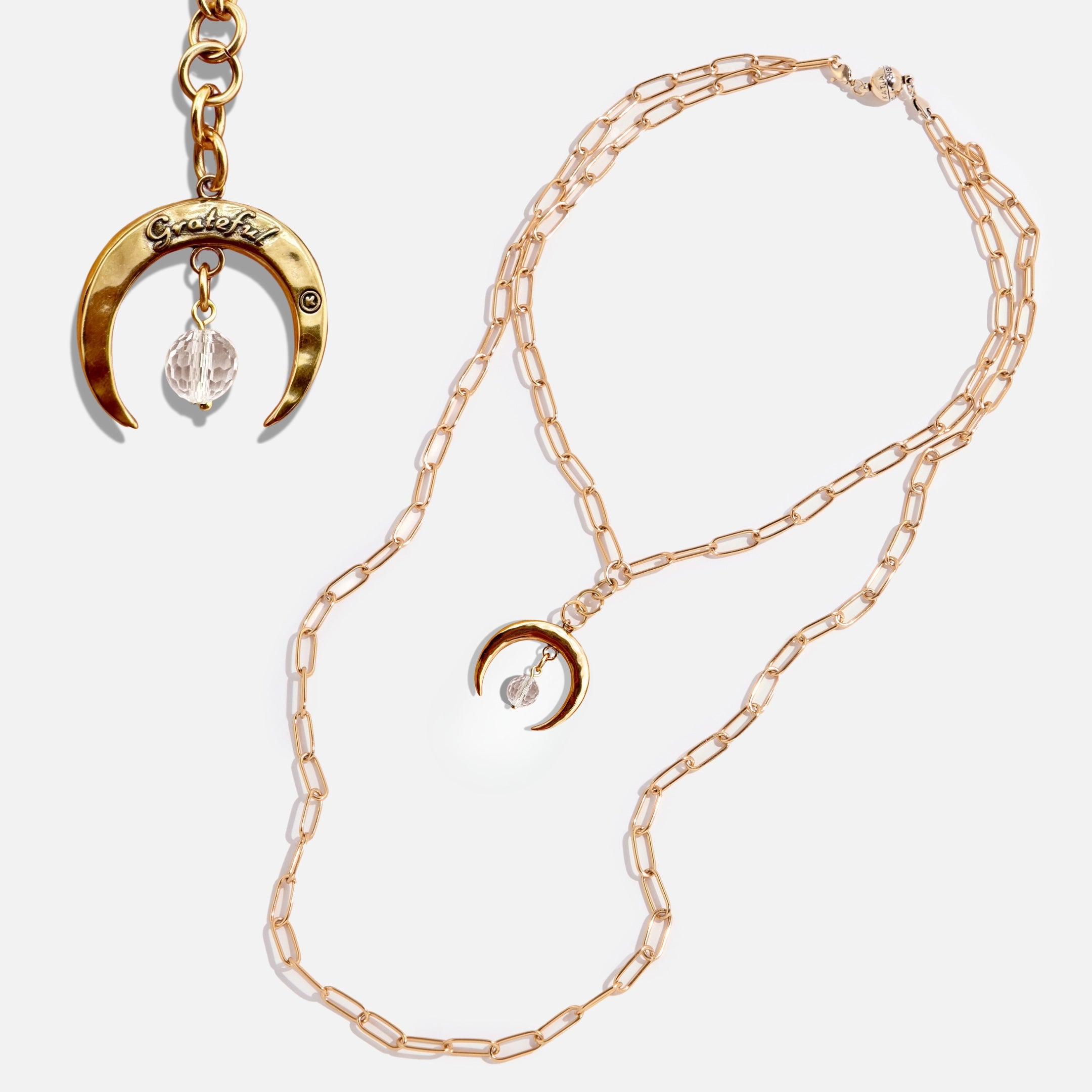 Gold necklace with crescent moon pendant and matching keychain on a light background