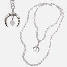 Silver necklace with crescent moon pendant on a white background