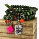 A green wooden bead bracelet with pink and orange accents, featuring a heart-shaped clasp and charms including a pink star and a metallic heart with the quote 'Do or Do Not There is No Try'.