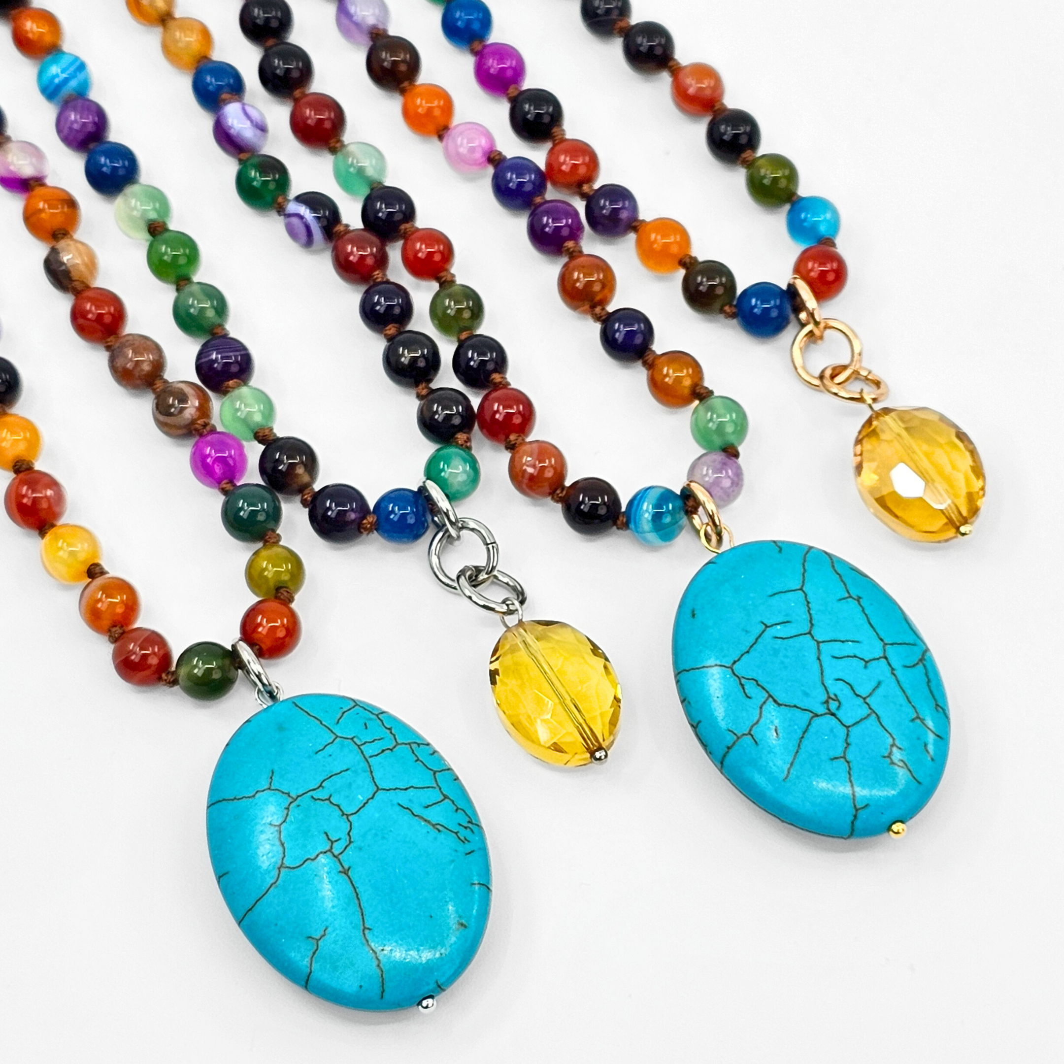 Colorful beaded necklaces with turquoise pendants on a white background