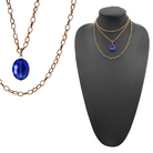 Two chain necklaces, one with a silver finish and the other with an antique gold finish, each featuring a large faceted royal blue crystal.