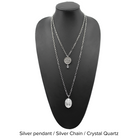 Two versions of the 'Just Breathe Lotus Original Necklace,' one with a gold finish and a lotus flower design, and another with a silver finish with the text 'JUST BREATHE' on it, both with beaded chains and a crystal accent.