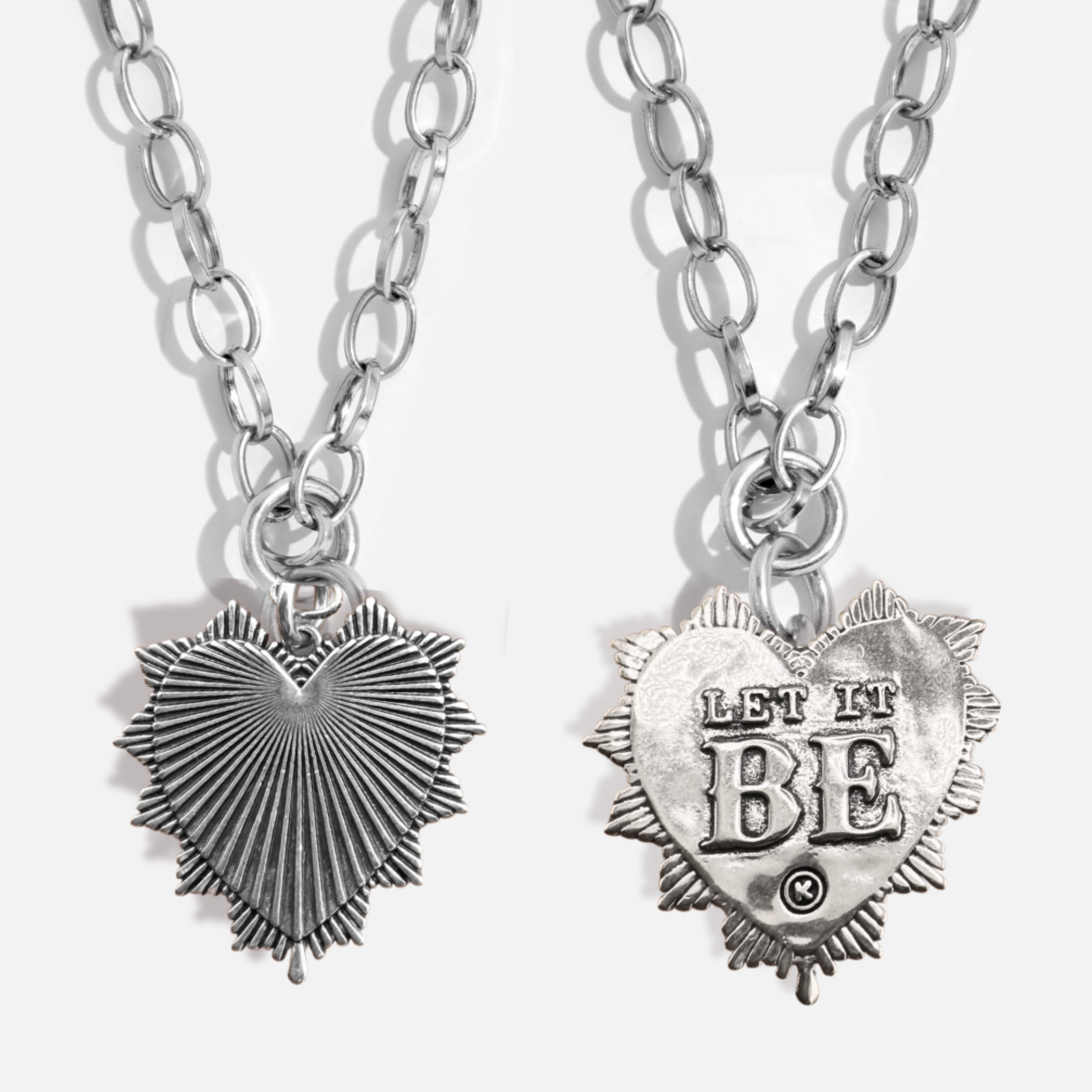 Two silver heart-shaped pendants on chains with one reading 'LET IT BE'.