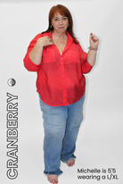 Woman wearing a red blouse and blue jeans on a white background with 'Cranberry' text.