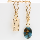 A person wearing a denim shirt and a white lace top, showcasing a silver-colored stainless steel chain necklace with a square pendant.