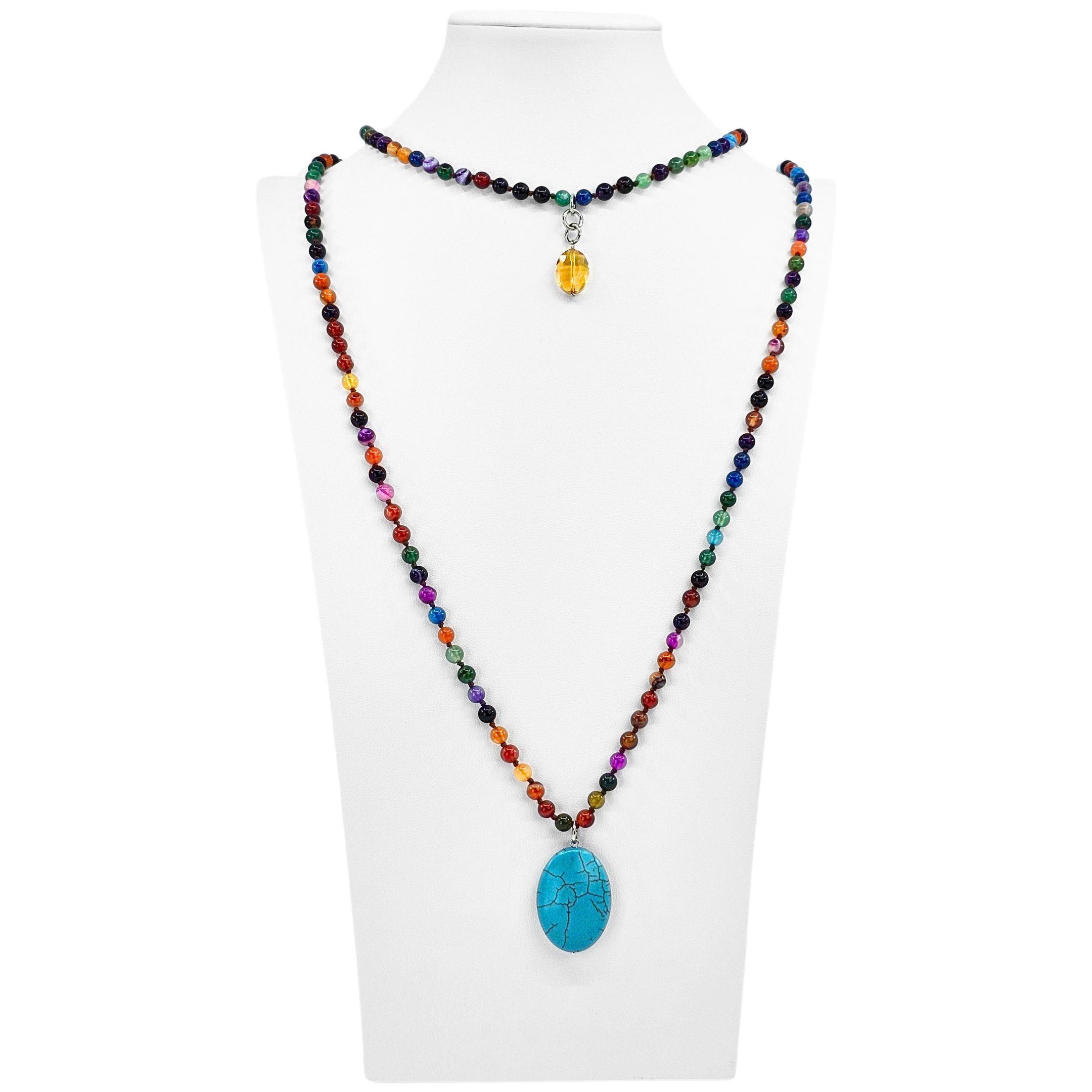 Colorful beaded necklace with a blue pendant on a white mannequin.