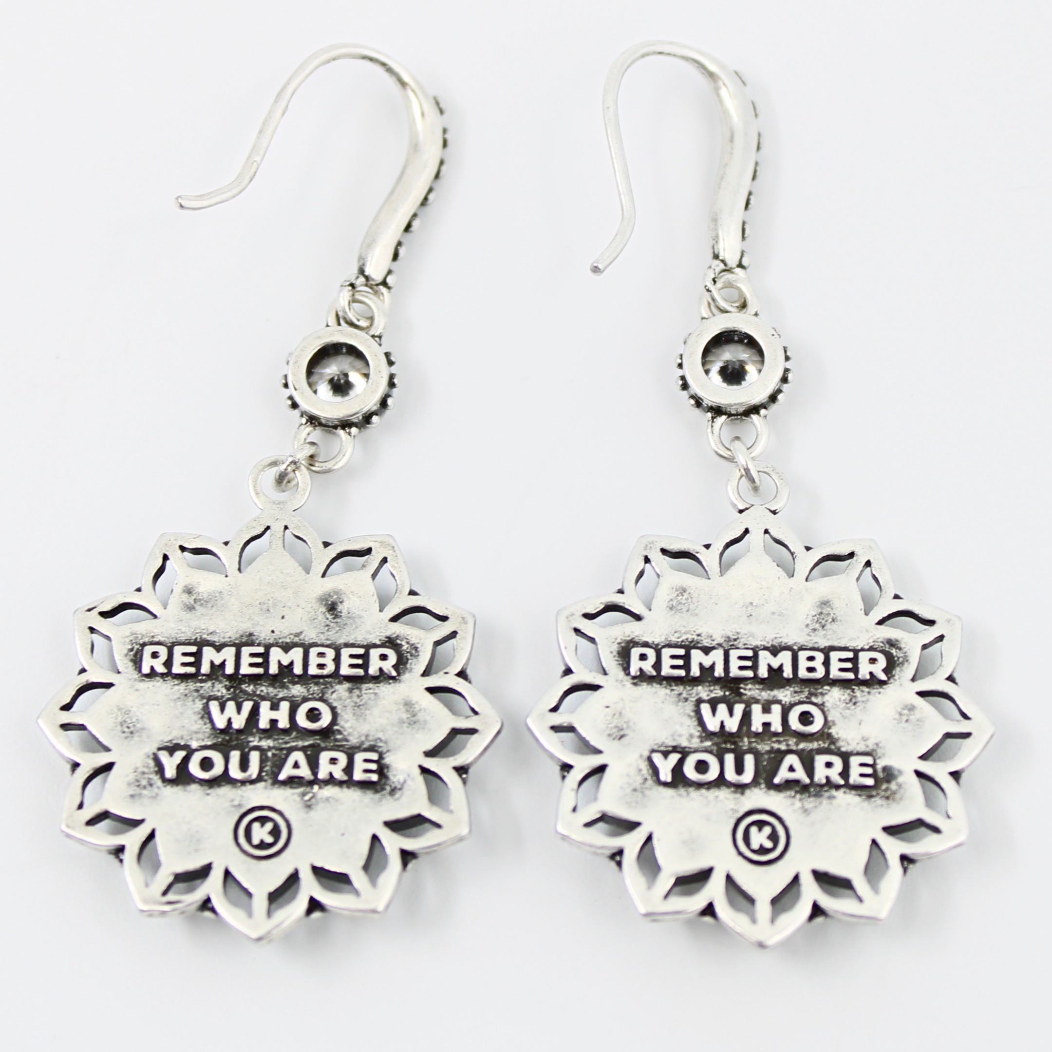 Silver earrings with 'Remember Who You Are' inscription on a white background