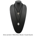 Two versions of the 'Just Breathe Lotus Original Necklace,' one with a gold finish and a lotus flower design, and another with a silver finish with the text 'JUST BREATHE' on it, both with beaded chains and a crystal accent.