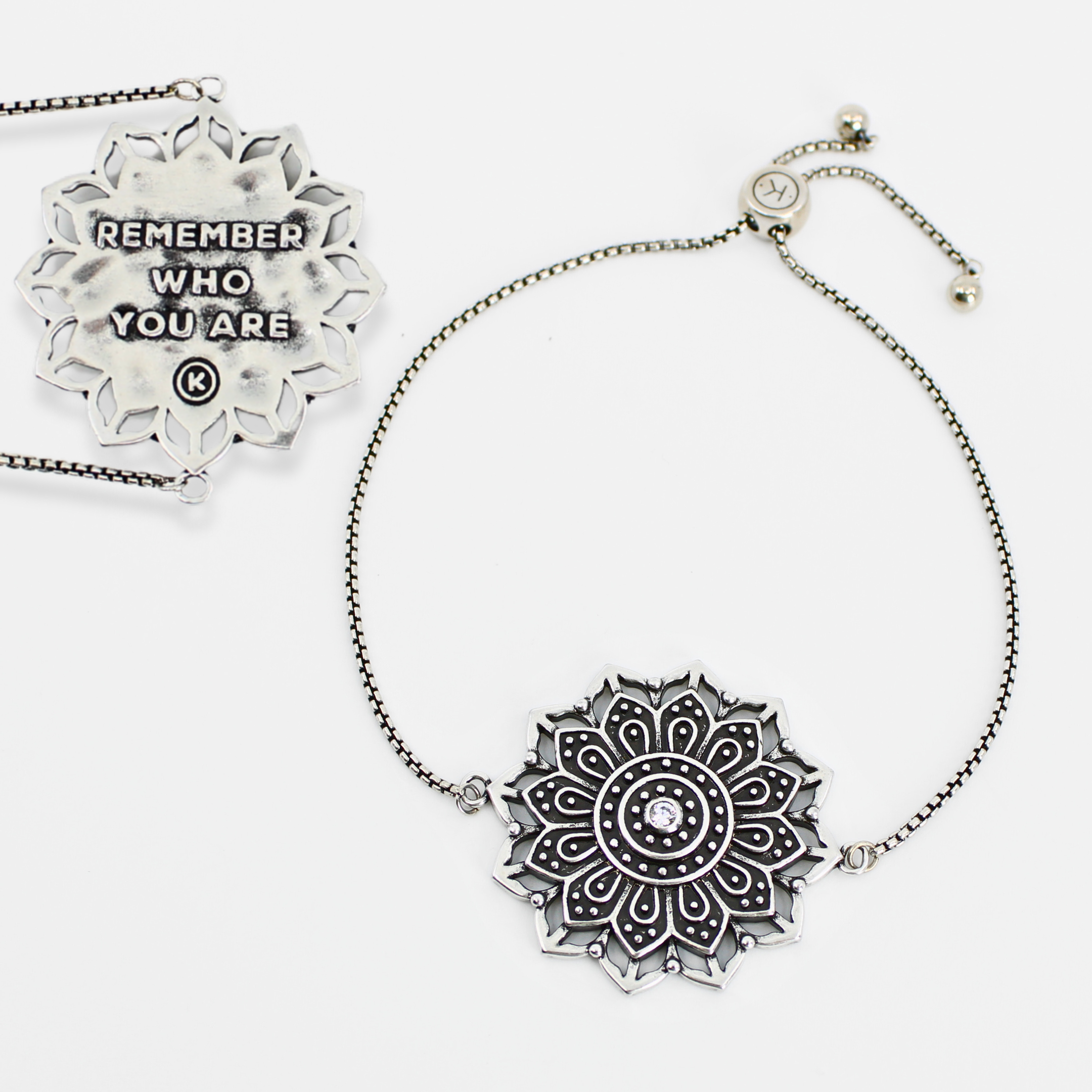 Silver mandala pendant necklace with motivational quote on a white background
