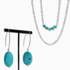 Turquoise pendant necklace with a silver chain on a white background