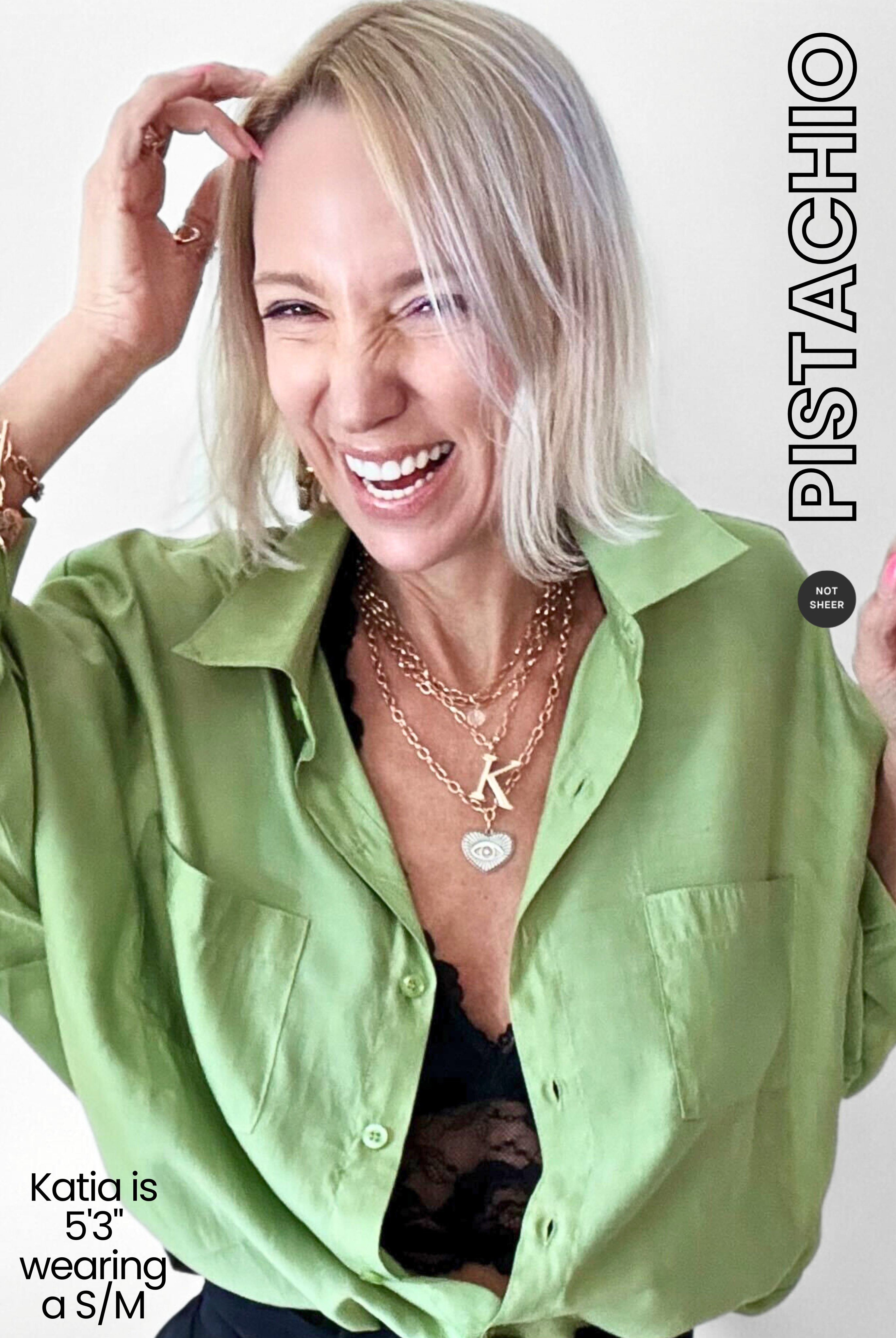 Woman wearing a green shirt with visible branding and text on a white background