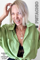 Woman wearing a green shirt with visible branding and text on a white background