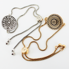 Two necklaces, one silver and one gold, with decorative pendants on a white background.