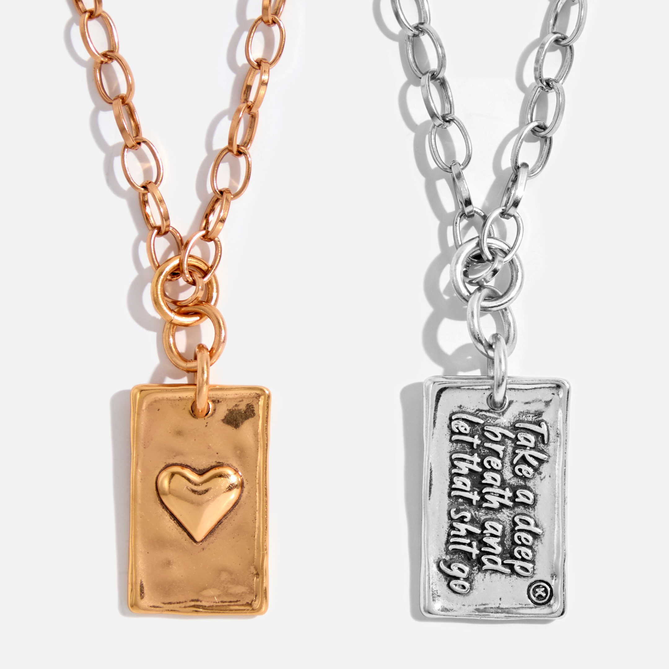 Two necklaces, one with an antique gold finish and a heart-shaped pendant, and the other with an antique silver finish and a rectangular pendant with text.