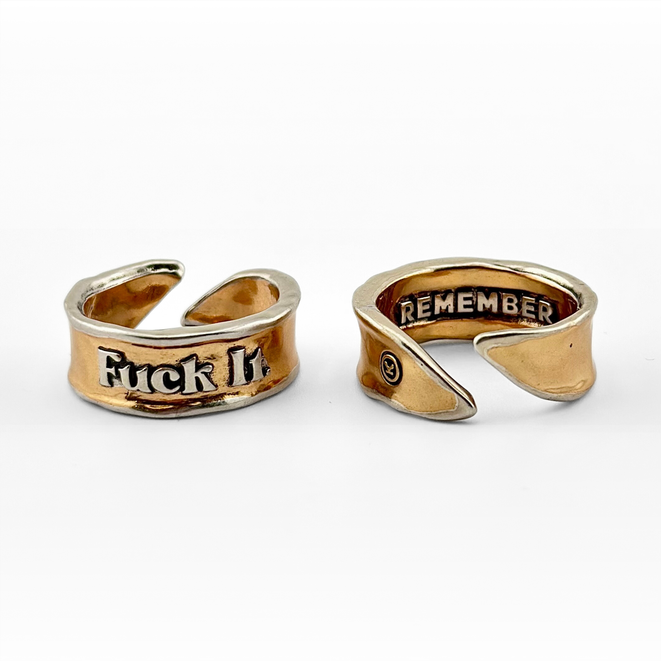 An adjustable ring with the inscription 'F*ck It Remember' on a white background, available in gold and silver colors.
