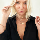 A person wearing a crystal beige Boho necklace with gold finish pendant and crystal quartz paired with blue apatite.