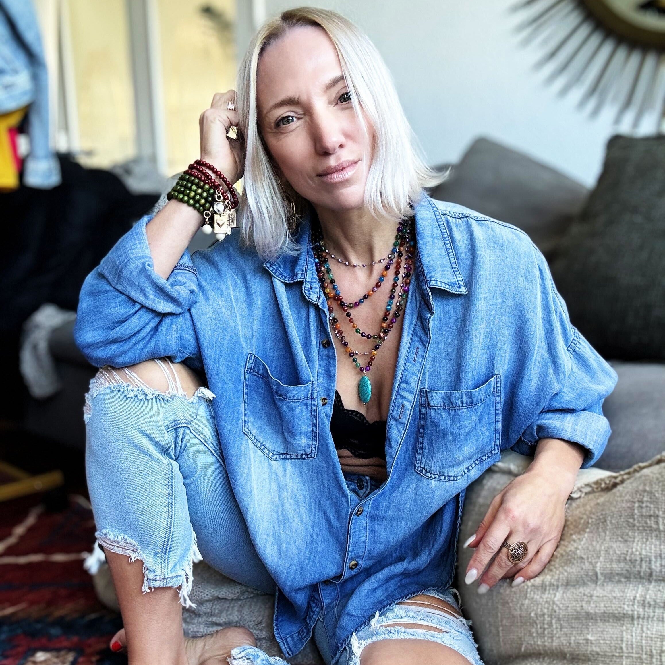 Woman in denim outfit sitting on a couch in a casual setting