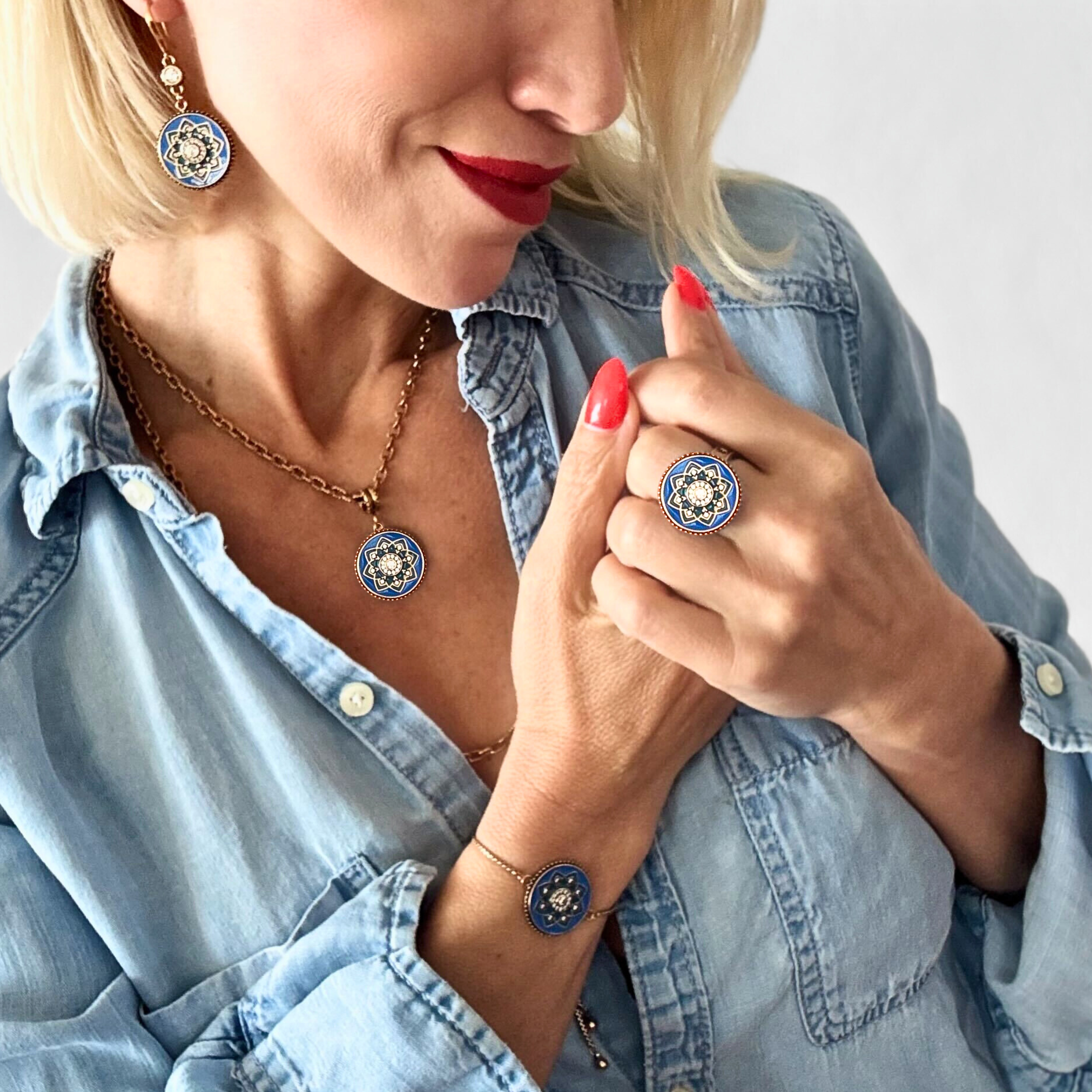 Woman wearing a blue and gold necklace, ring, and earring set.